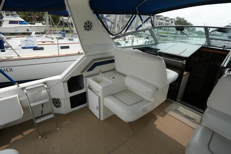 Slide: The Image of 1993 Sea Ray 400 Express Cruiser interior with white seating and helm station. - 9