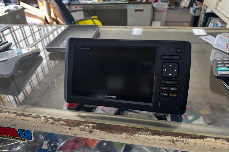 Slide: The Image of Garmin echoMAP CV device on a glass counter, surrounded by electronics and papers. - 12