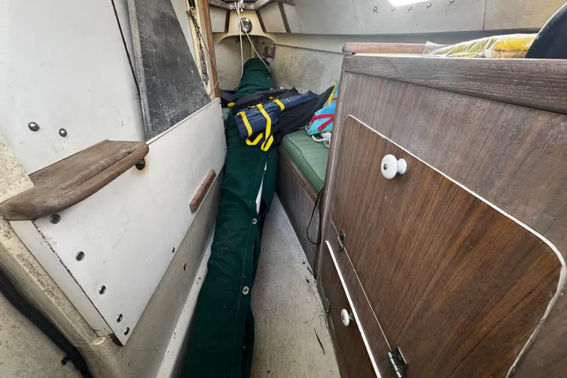 Slide: The Image of Interior of a 1976 custom wooden sloop with storage and seating area. - 19