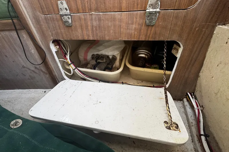Slide: The Image of Storage compartment in a 1976 Custom Wooden Sloop, featuring tools and wiring. - 21