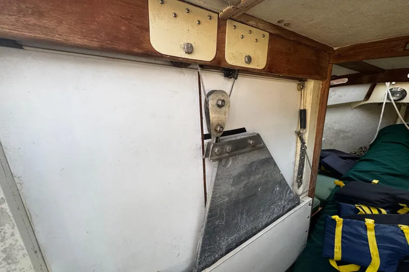 Slide: The Image of Interior of a 1976 Custom Wooden Sloop, featuring a pulley system and storage area. - 22