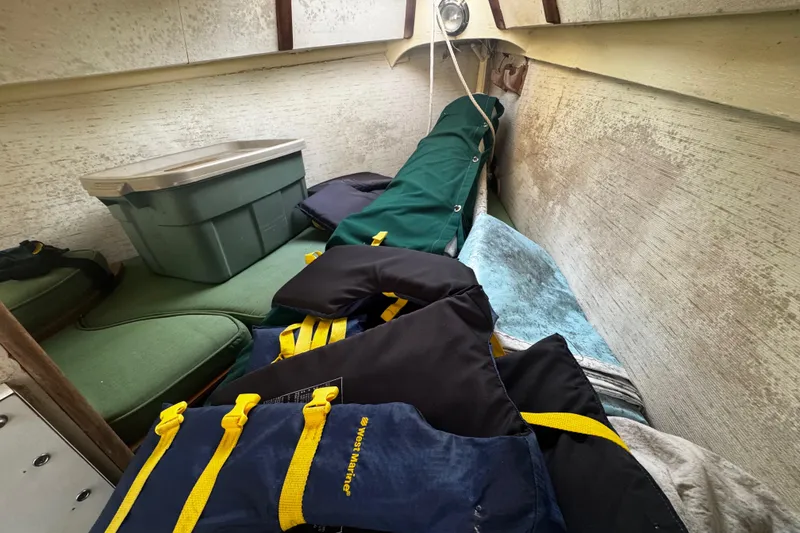Slide: The Image of Interior of a 1976 Custom Wooden Sloop with storage items and life jackets. - 24
