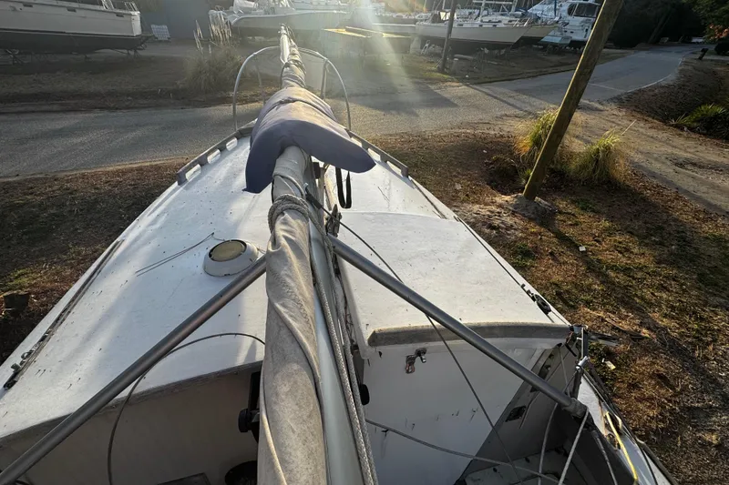 Slide: The Image of 1976 Custom Wooden Sloop on land, mast covered, surrounded by other boats. - 29