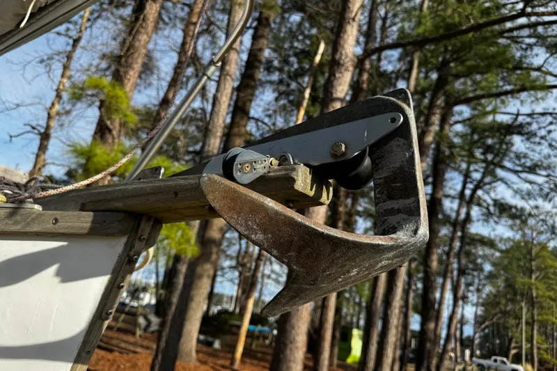 Slide: The Image of Close-up of a 1976 Custom Wooden Sloop anchor against a forest backdrop. - 32