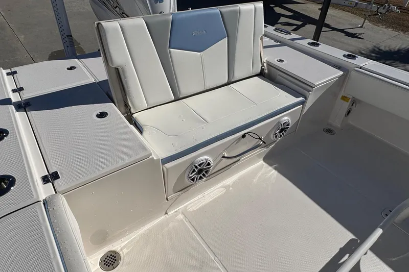 Slide: The Image of 2023 Robalo 266 Cayman boat interior with cushioned seating and built-in speakers. - 11