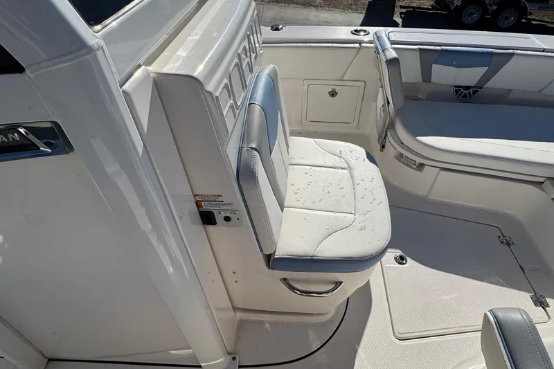 Slide: The Image of 2023 Robalo 266 Cayman boat interior with cushioned seating and storage compartments. - 20