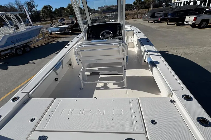 Slide: The Image of 2023 Robalo 266 Cayman boat interior with seating and console, parked outdoors. - 22
