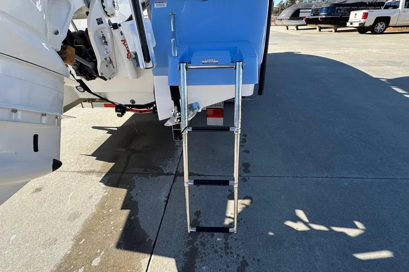 Slide: The Image of 2023 Robalo 266 Cayman boat with extended swim ladder on concrete surface. - 24