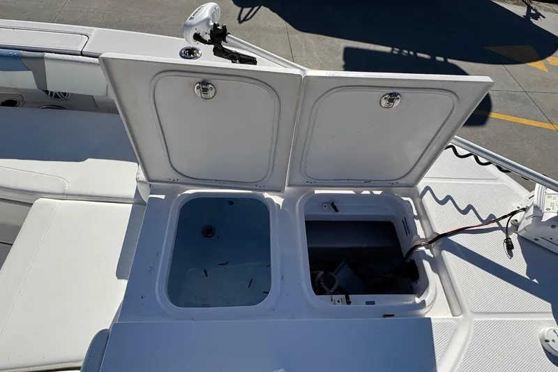 Slide: The Image of 2023 Robalo 266 Cayman boat storage compartments open on deck. - 25