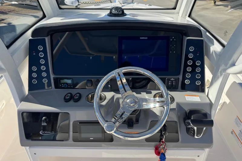 Slide: The Image of 2023 Robalo 266 Cayman boat dashboard with steering wheel and control panel. - 7