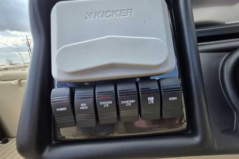 Slide: The Image of 2026 Veranda VR22RC Tri-Toon boat on trailer, parked beside a metal building under a blue sky. - 21