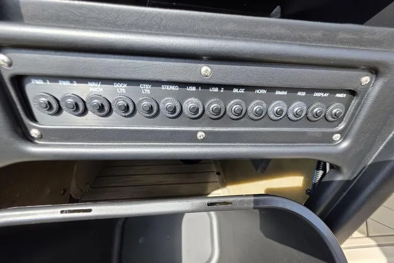 Slide: The Image of 2026 Veranda VR22RC Tri-Toon boat rear view, parked on gravel near a metal building. - 35