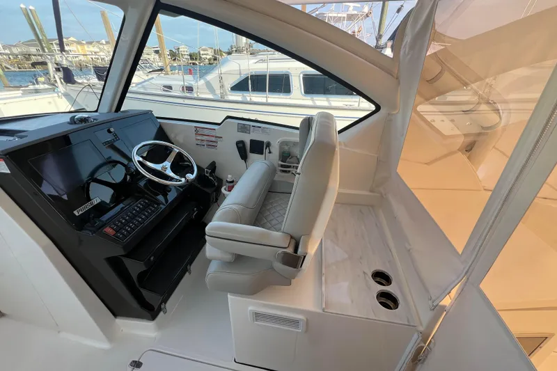 Slide: The Image of 2024 Pursuit DC 326 Dual Console interior with helm, steering wheel, and seating. - 10
