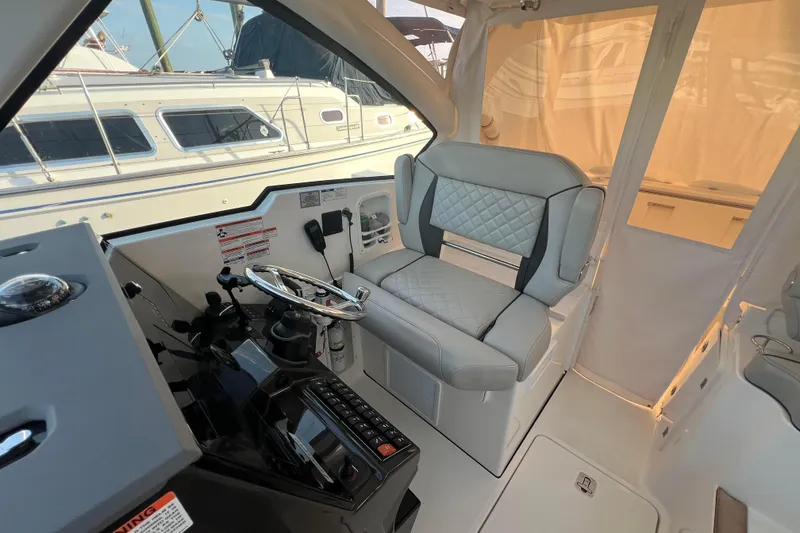 Slide: The Image of 2024 Pursuit DC 326 Dual Console interior with luxurious seating and modern helm controls. - 11