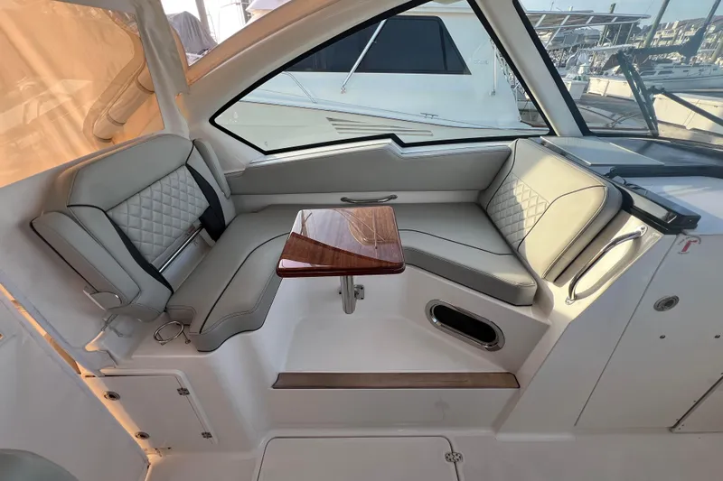 Slide: The Image of 2024 Pursuit DC 326 Dual Console interior with elegant seating and wooden table. - 13