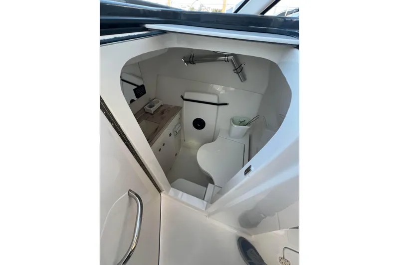 Slide: The Image of 2024 Pursuit DC 326 Dual Console boat interior with compact bathroom amenities. - 15