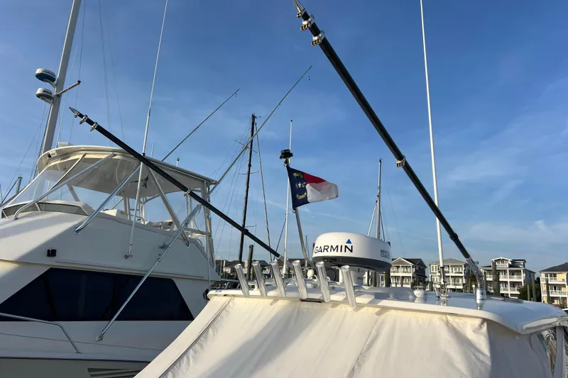 Slide: The Image of 2024 Pursuit DC 326 Dual Console boat with Garmin radar, docked under clear blue sky. - 18