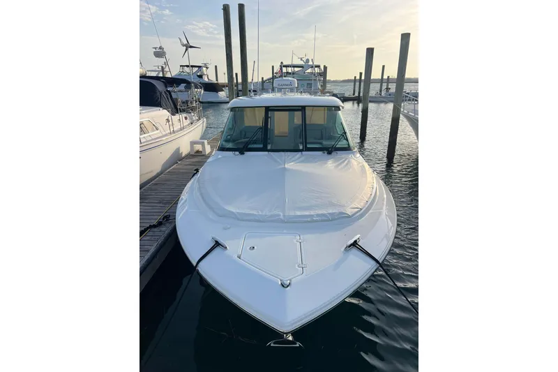 Slide: The Image of 2024 Pursuit DC 326 Dual Console boat docked at marina, front view. - 19