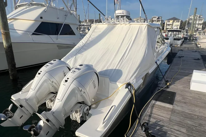 Slide: The Image of 2024 Pursuit DC 326 Dual Console boat docked with twin Yamaha outboard engines. - 4