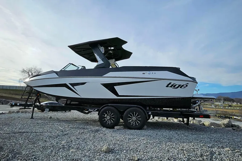 Slide: The Image of 2026 Tigé 24RZX boat on trailer, sleek design, parked on gravel. - 9