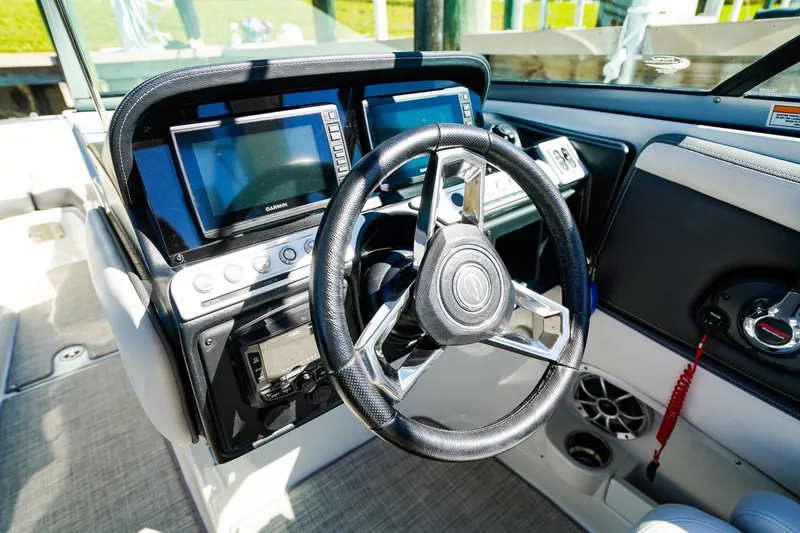 Slide: The Image of 2023 Crownline 270 XSS boat dashboard with steering wheel and navigation screens. - 16