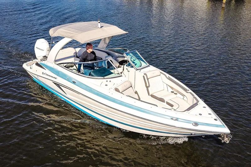 Slide: The Image of 2023 Crownline 270 XSS boat cruising on water, featuring sleek design and spacious seating. - 22