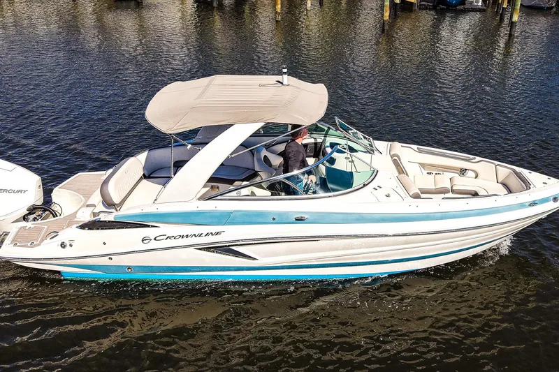 Slide: The Image of 2023 Crownline 270 XSS boat cruising on water, featuring sleek design and spacious seating. - 23