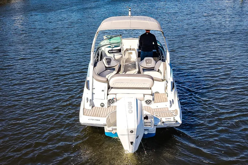 Slide: The Image of 2023 Crownline 270 XSS boat cruising on open water, rear view. - 24