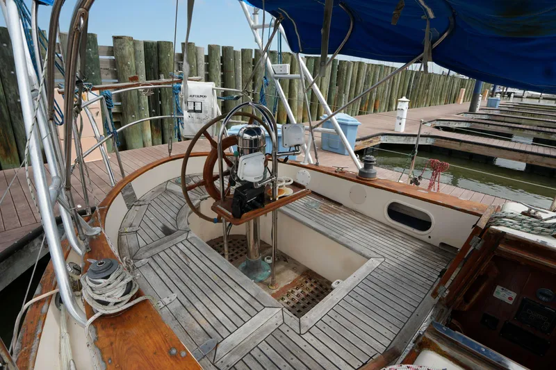 Slide: The Image of Cockpit of 1983 Tayana 37 sailboat with wooden deck and steering wheel at marina. - 10