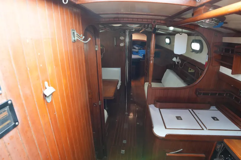 Slide: The Image of Interior of 1983 Tayana 37 sailboat, featuring wooden paneling and compact living space. - 13