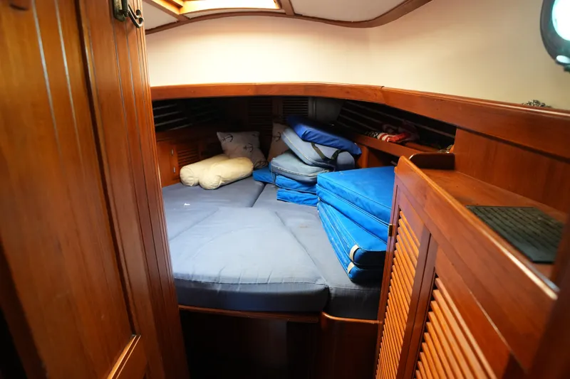 Slide: The Image of Cozy cabin interior of 1983 Tayana 37 sailboat with wooden finish and blue cushions. - 14