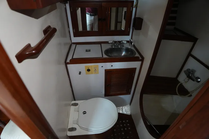 Slide: The Image of 1983 Tayana 37 yacht bathroom with sink, toilet, and wooden accents. - 17