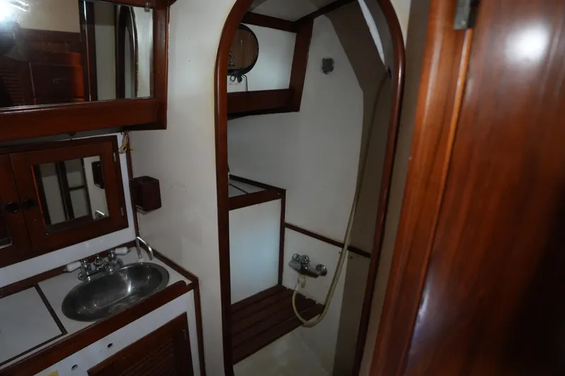 Slide: The Image of 1983 Tayana 37 yacht bathroom with sink, mirror, and shower area. - 18