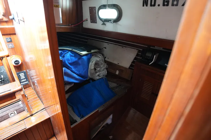 Slide: The Image of Interior of 1983 Tayana 37 sailboat with wooden paneling and storage area. - 23