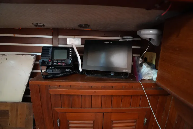 Slide: The Image of Navigation equipment inside 1983 Tayana 37 sailboat, featuring Raymarine display and radio. - 24