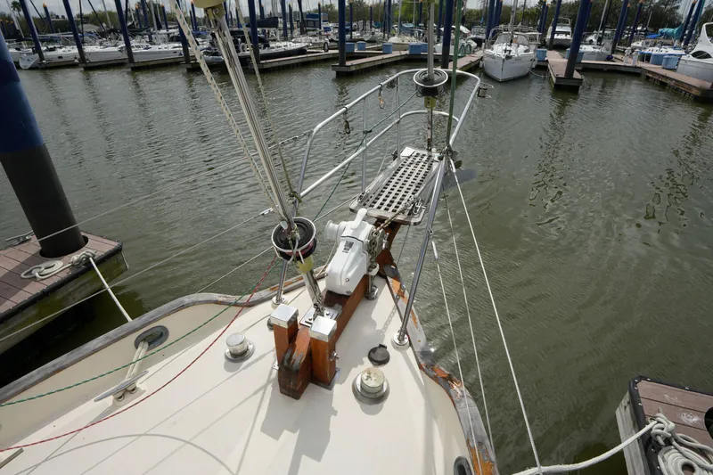 Slide: The Image of 1983 Tayana 37 sailboat docked at marina, showing bow and rigging details. - 6