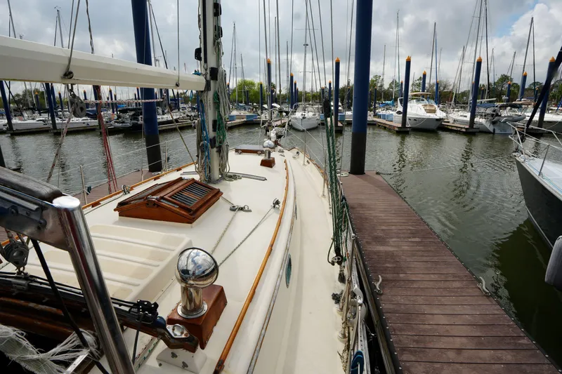 Slide: The Image of 1983 Tayana 37 sailboat docked in a marina, surrounded by other boats. - 7