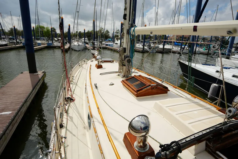 Slide: The Image of 1983 Tayana 37 sailboat docked in a marina, surrounded by other boats. - 8