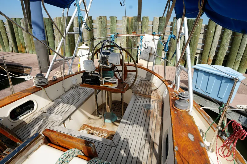 Slide: The Image of Cockpit of 1983 Tayana 37 sailboat with wooden accents and nautical equipment. - 9