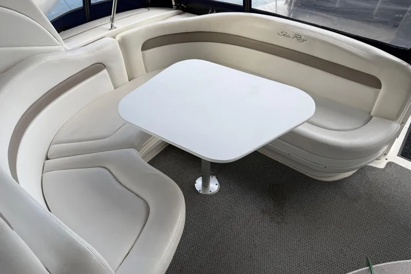 Slide: The Image of Interior seating area of 2005 Sea Ray Sundancer 320 with white table and cushioned seats. - 15