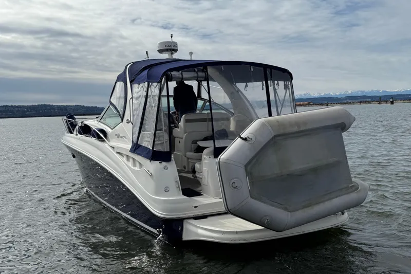 Slide: The Image of 2005 Sea Ray Sundancer 320 boat on water, featuring a covered cockpit and scenic background. - 2