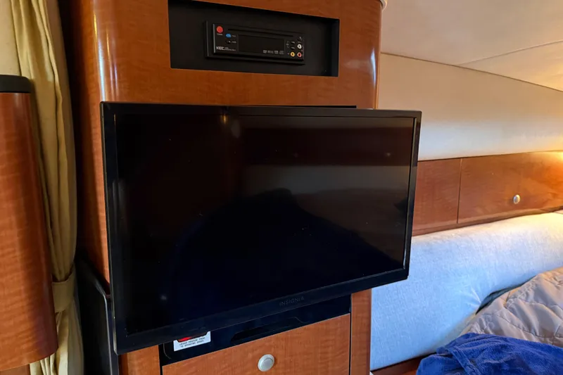 Slide: The Image of Flat-screen TV in 2005 Sea Ray Sundancer 320 cabin, with wood paneling and cozy bedding. - 25