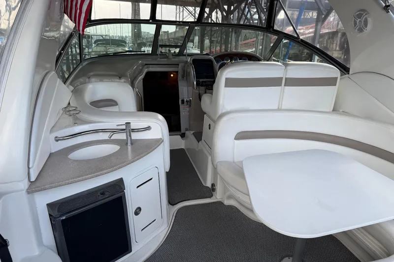 Slide: The Image of 2005 Sea Ray Sundancer 320 interior with white seating, table, and kitchenette. - 3