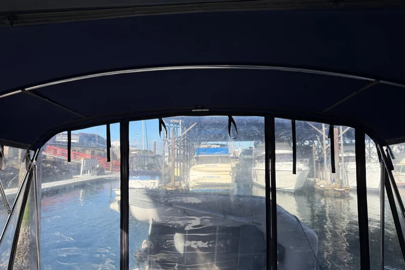 Slide: The Image of 2005 Sea Ray Sundancer 320 interior view, docked at a marina with surrounding boats. - 50