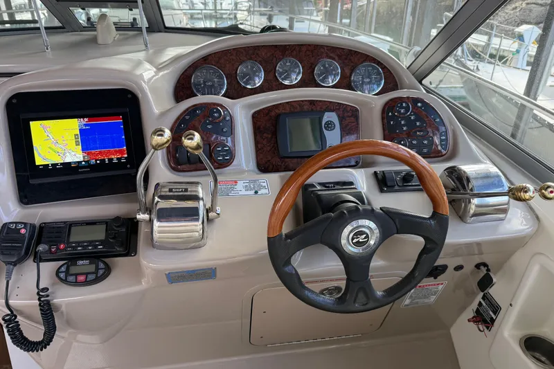 Slide: The Image of 2005 Sea Ray Sundancer 320 helm with navigation controls and wooden steering wheel. - 7