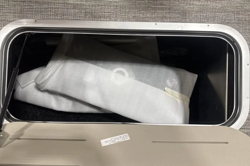 Slide: The Image of Storage compartment in 2026 Bennington 25 LTSBSF boat with folded white fabric inside. - 12