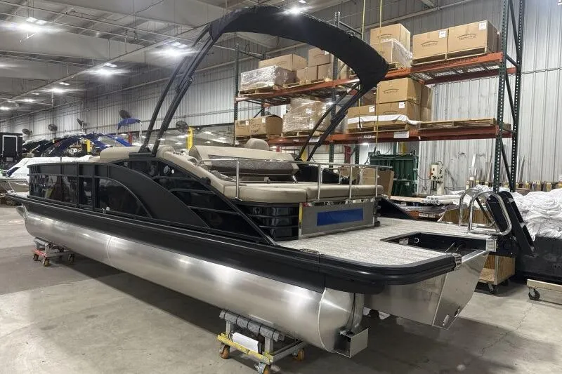 Slide: The Image of 2026 Bennington 25 LTSBSF pontoon boat in warehouse, sleek design, luxury seating. - 2
