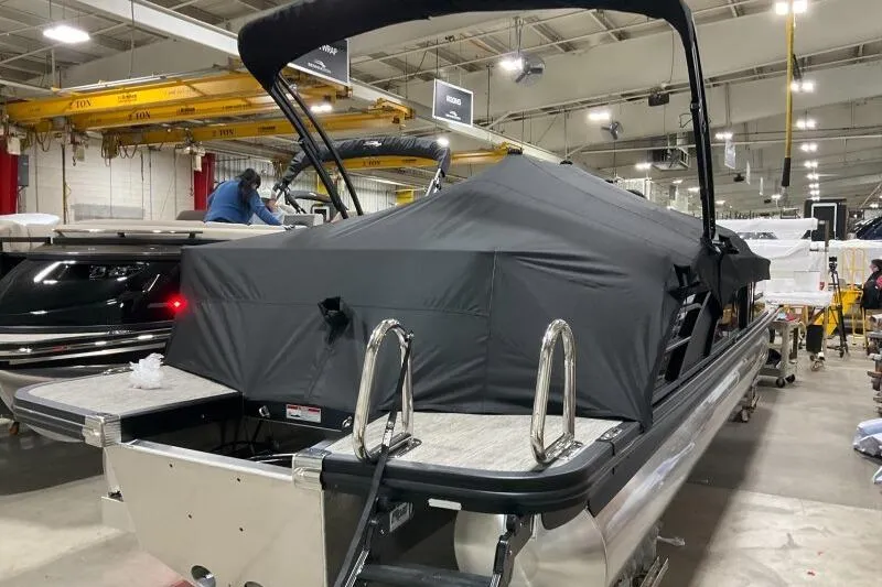 Slide: The Image of 2026 Bennington 25 LTSBSF pontoon boat covered in a factory setting. - 23
