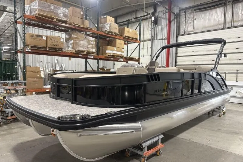 Slide: The Image of 2026 Bennington 25 LTSBSF pontoon boat in warehouse, surrounded by shelves and boxes. - 7