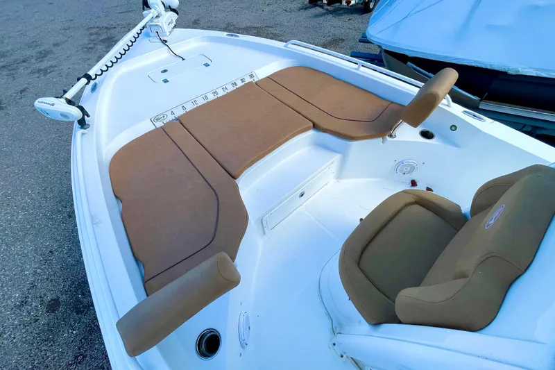 Slide: The Image of 2021 Sea Hunt BX 25 FS boat interior with cushioned seating and fishing rod holders. - 20